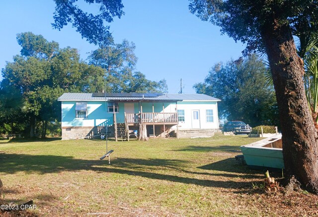 back of property featuring a lawn and a wooden deck