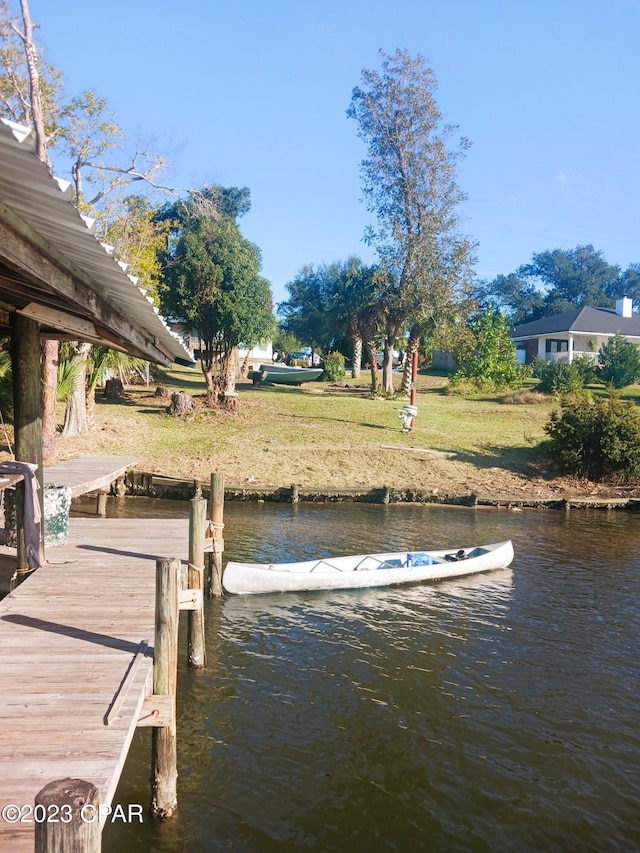 dock area with a yard and a water view