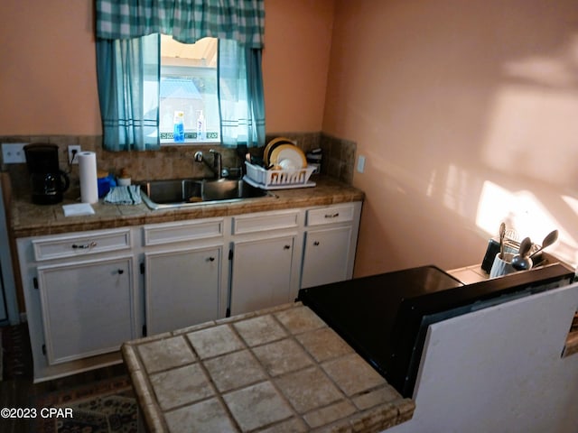 kitchen featuring white cabinets and sink