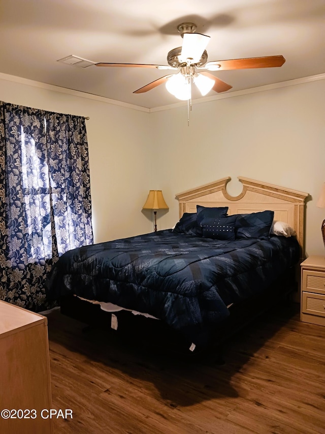 bedroom with hardwood / wood-style floors, ceiling fan, and crown molding