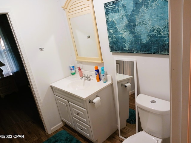 bathroom with vanity, wood-type flooring, and toilet