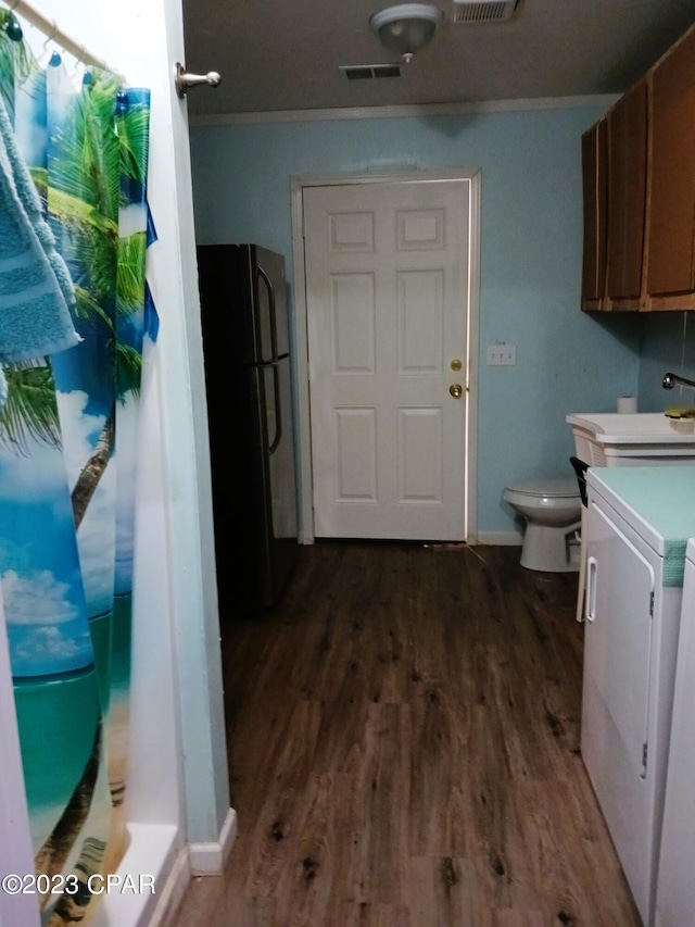 clothes washing area featuring ornamental molding, sink, dark wood-type flooring, and washer / dryer