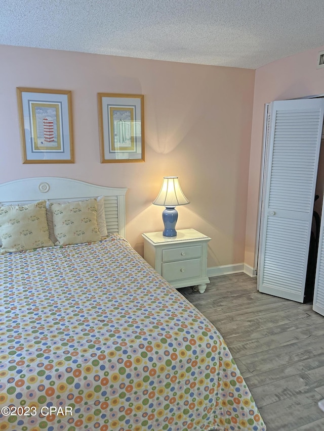 bedroom featuring a closet, a textured ceiling, and light wood-type flooring