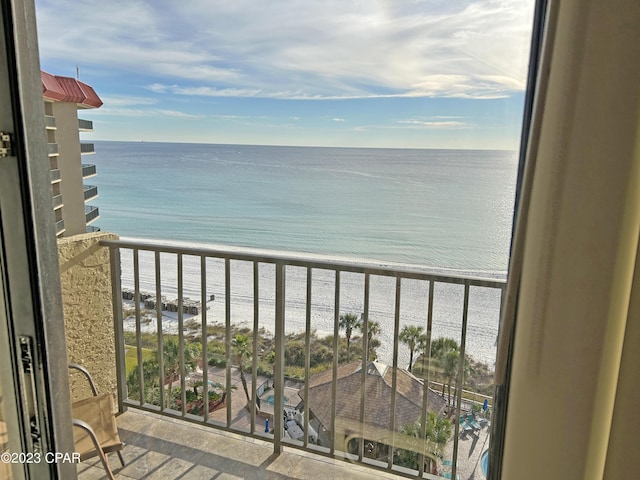 balcony featuring a view of the beach and a water view