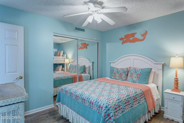 bedroom with a textured ceiling, ceiling fan, a closet, and dark hardwood / wood-style floors