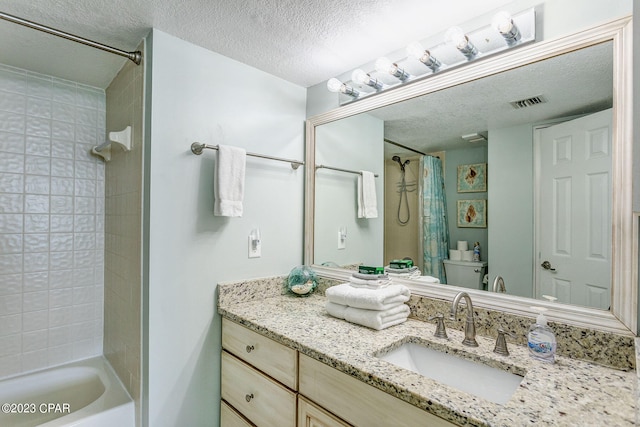 full bathroom featuring vanity, a textured ceiling, shower / tub combo with curtain, and toilet