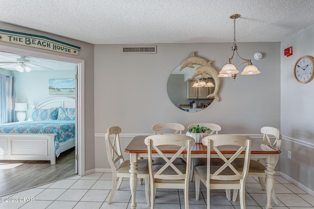 dining room featuring ceiling fan, a textured ceiling, and light wood-type flooring