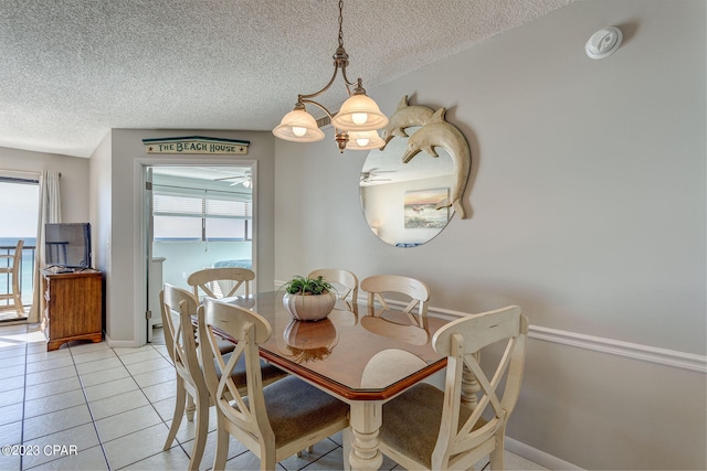 tiled dining space with a textured ceiling and a notable chandelier