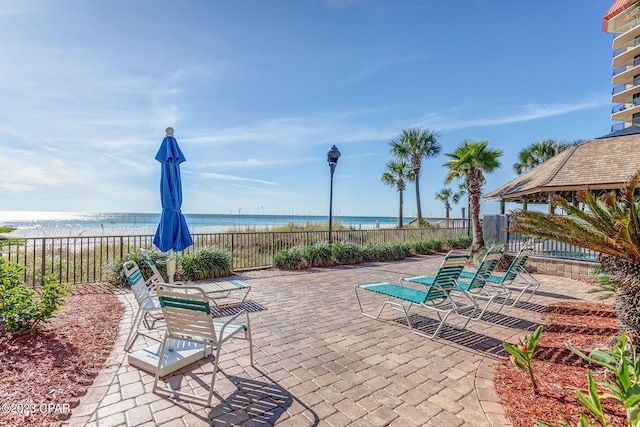 view of patio / terrace featuring a beach view and a water view