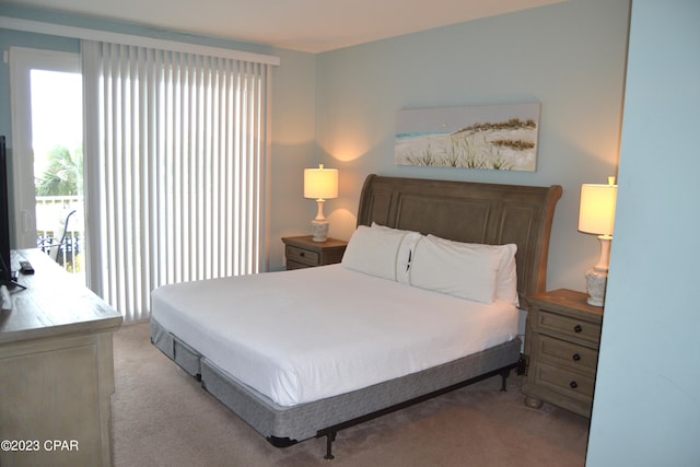 bedroom with access to outside and light colored carpet