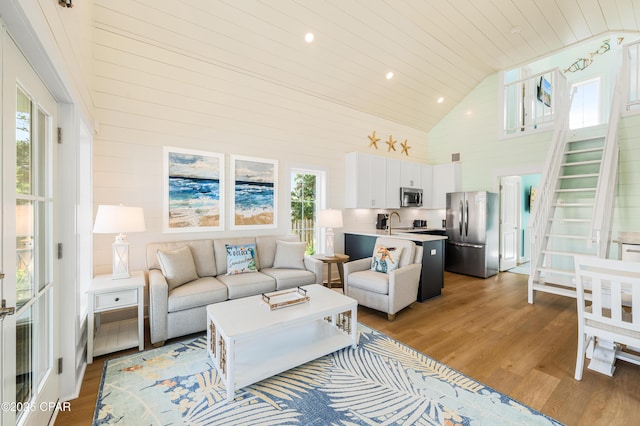 living room with high vaulted ceiling, wood ceiling, sink, and light hardwood / wood-style floors