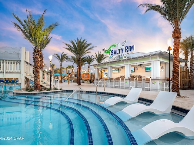 pool at dusk with exterior bar