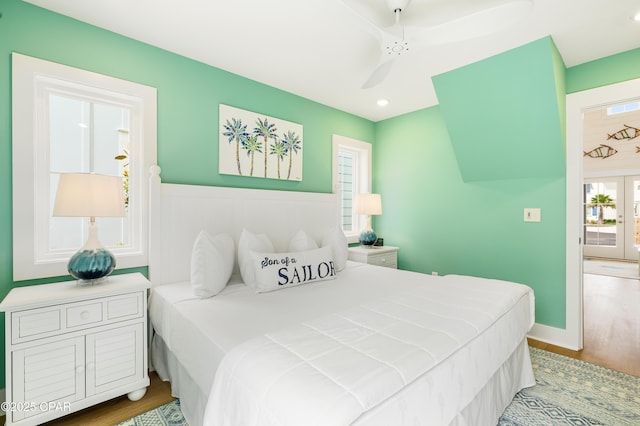 bedroom featuring ceiling fan, hardwood / wood-style floors, and french doors