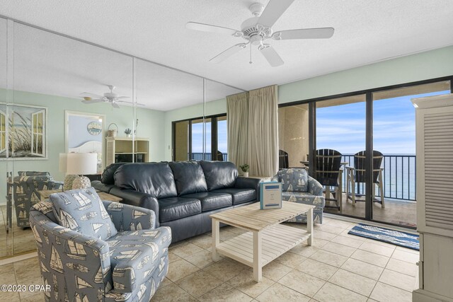 tiled living room featuring a textured ceiling and ceiling fan