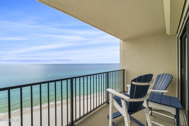 balcony featuring a water view and a beach view