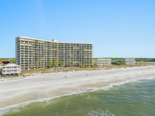 birds eye view of property featuring a water view and a beach view