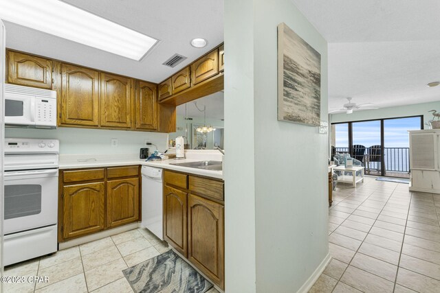 kitchen with sink, ceiling fan, light tile patterned floors, and white appliances