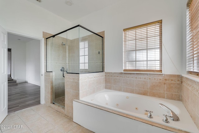 bathroom with hardwood / wood-style floors and shower with separate bathtub