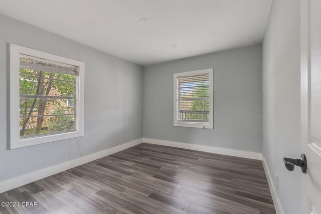 empty room with plenty of natural light and dark hardwood / wood-style floors