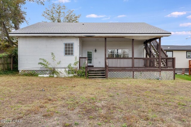 back of property with a lawn and a wooden deck