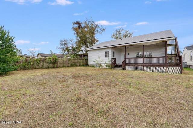 rear view of house with a lawn and a wooden deck