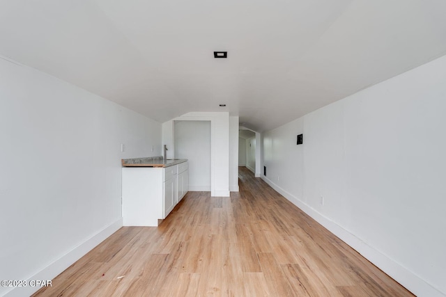 unfurnished living room featuring lofted ceiling and light hardwood / wood-style flooring