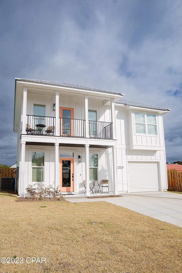 view of front of home featuring a garage, a front yard, and a balcony