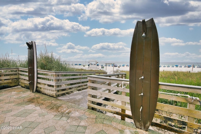 view of gate featuring a view of the beach and a water view