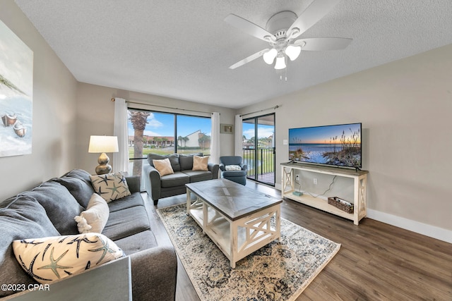 living room featuring ceiling fan, dark hardwood / wood-style flooring, and a textured ceiling