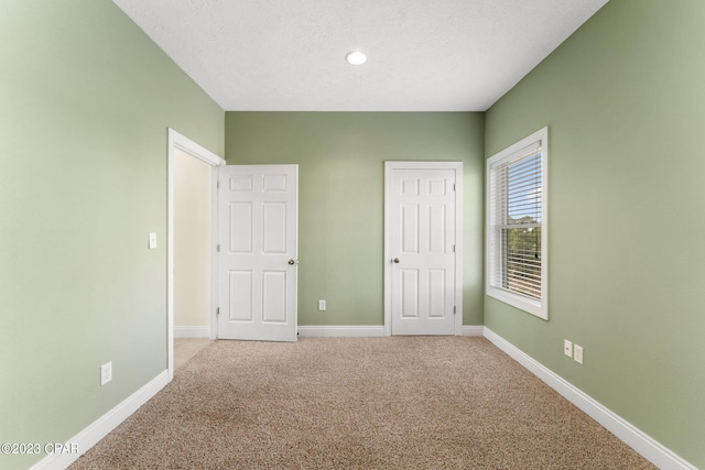 unfurnished bedroom featuring a textured ceiling and carpet floors