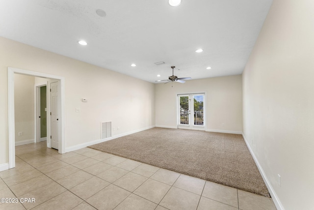 empty room featuring ceiling fan, light tile patterned floors, and french doors