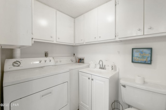 laundry room featuring sink, washer and dryer, and a textured ceiling