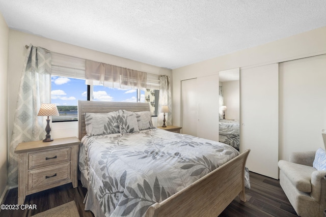 bedroom with dark wood-type flooring and a textured ceiling