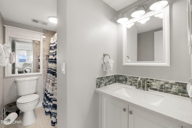 bathroom featuring tile patterned flooring, vanity, decorative backsplash, and toilet