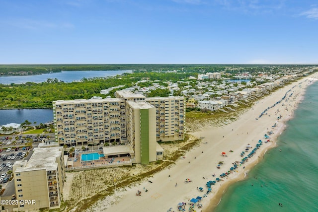 birds eye view of property with a water view and a beach view