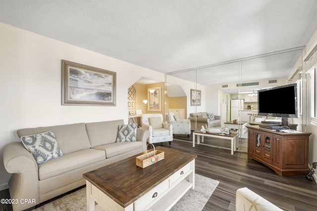 living room featuring dark hardwood / wood-style floors and a textured ceiling