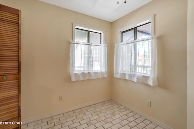 unfurnished room featuring a healthy amount of sunlight and light tile patterned floors