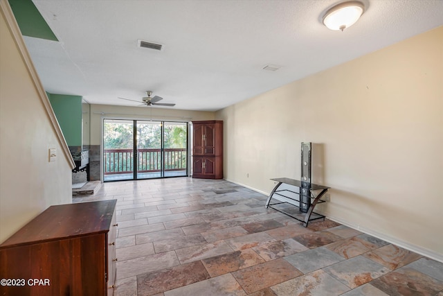 unfurnished living room with tile patterned flooring and ceiling fan