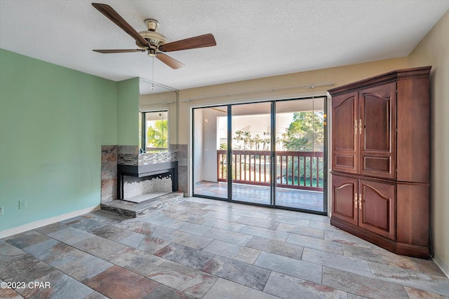 unfurnished living room with a textured ceiling, light tile patterned floors, and ceiling fan