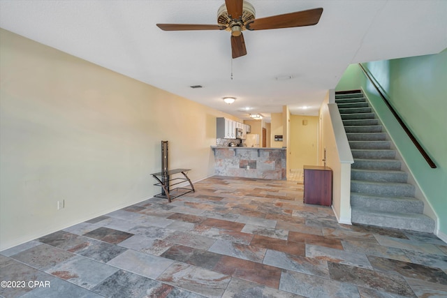 unfurnished living room with tile patterned flooring and ceiling fan