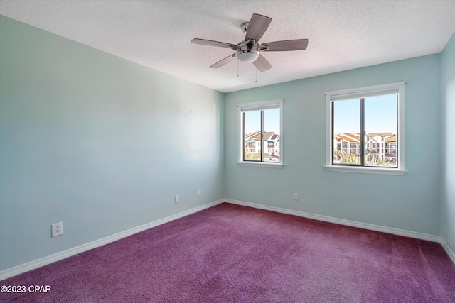 carpeted spare room with a textured ceiling and ceiling fan