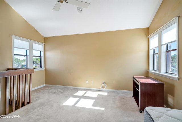 empty room featuring lofted ceiling, light colored carpet, and ceiling fan