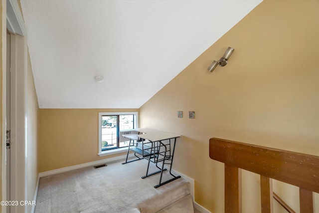 interior space featuring vaulted ceiling and light colored carpet