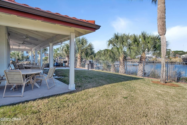 view of yard featuring a water view, a patio, and ceiling fan