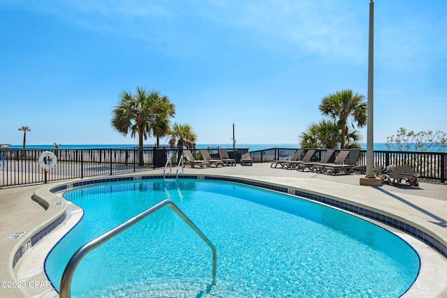 view of swimming pool with a patio area and a water view