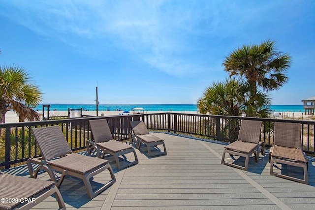 wooden deck with a water view and a view of the beach