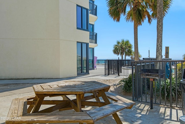 view of patio featuring a water view and a balcony