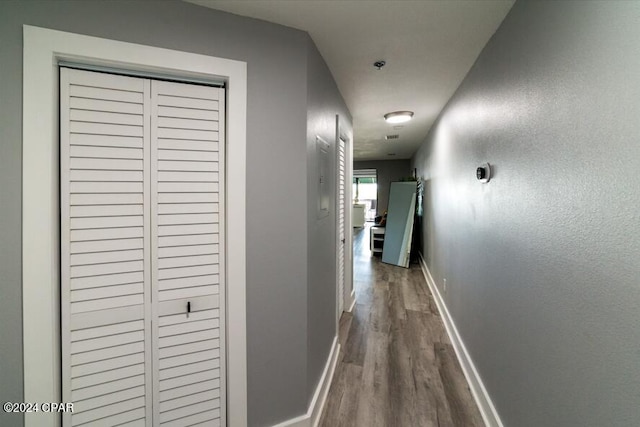 corridor featuring baseboards and wood finished floors