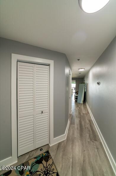 hall with baseboards and wood finished floors