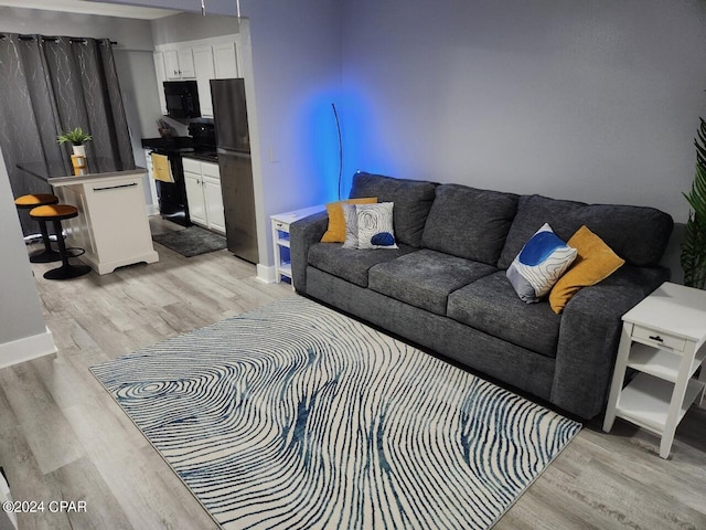 living area featuring light wood-style flooring and baseboards